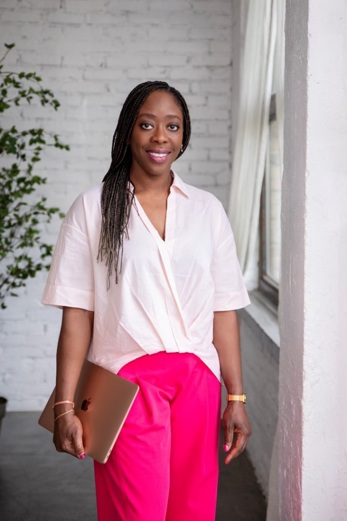 Confident Black businesswoman holding a laptop in Budapest.