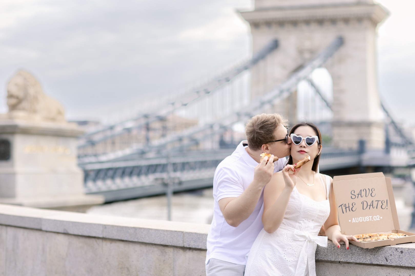 Couple standing on the Chain Bridge during sunset in Budapest
